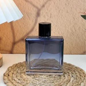Vista di dettaglio di un flacone di profumo quadrato in vetro blu con tappo nero.