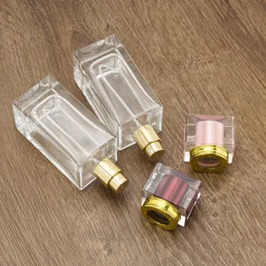 Detail view of 50ml square glass perfume bottles with gold spray pumps and luxury crystal caps.