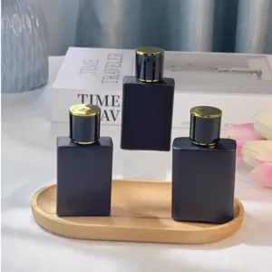 Frasco de perfume negro mate con tapa dorada, elegante botella cosmética recargable.