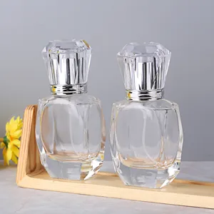 Gros plan sur un flacon de parfum en verre transparent avec bouchon en cristal sur support.