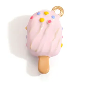 Detailed view of a sweet pink enamel popsicle pendant with colorful dots and a gold loop
