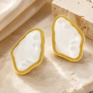 Close-up of retro irregular geometric stud earrings with white resin and gold-plated finish.