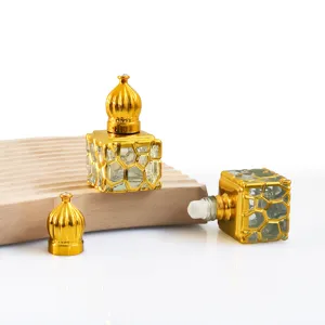 Gedetailleerd aanzicht van lege 10ml glazen etherische olie rollerfles met gouden metalen kooi.