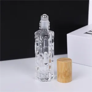Détail de flacon à bille en verre clair pour huile essentielle avec bouchon en bambou.