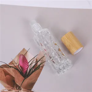 Vue détaillée du flacon à bille d'huile essentielle 10ml en verre texturé et bouchon en bambou.