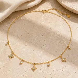 Vista detallada del collar chapado en oro con dijes de estrellas y circonitas brillantes.