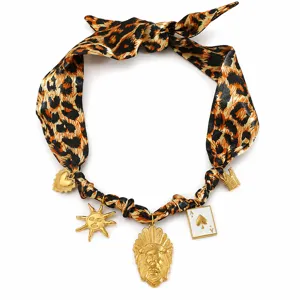Detailed view of leopard print silk necklace with multiple gold-toned vintage charms