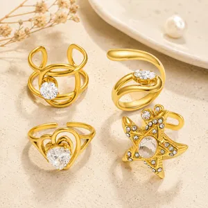 Primer plano de cuatro anillos de acero inoxidable dorados con diseños de corazón y estrella.
