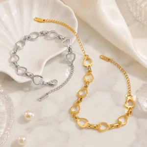 Gros plan détaillé des bracelets à maillons cœur en acier titane coloris or et argent.