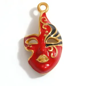 Close-up detail of a red and black enamel opera mask pendant in gold-plated steel