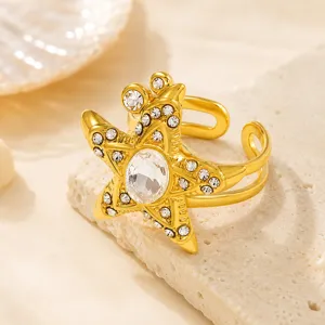 Vista detallada de un anillo de estrella de mar dorado con circonitas brillantes