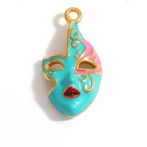 Close-up detail of a colorful turquoise and gold plated opera mask pendant for jewelry