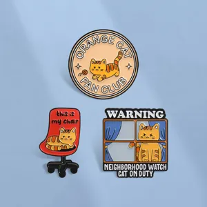 Detailopname van grappige oranje katten emaille pins met 'Cat On Duty' ontwerpen.