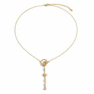 Detail showing intricate star and moon charms with rhinestones on gold Y-chain