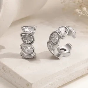 Close-up of teardrop-shaped cubic zirconia stones set in a polished stainless steel ear cuff.