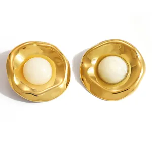 Macro detail of vintage gold-plated irregular texture earrings with resin center inlay