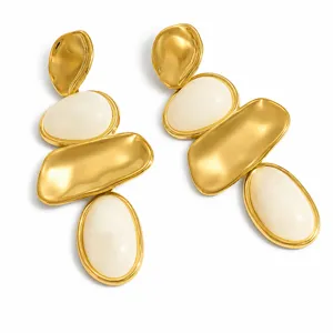 Detalle de pendientes geométricos de acero de titanio con inserciones de resina blanca