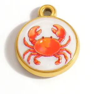 Macro di un ciondolo a forma di granchio in acciaio inossidabile dorato con pittura a olio