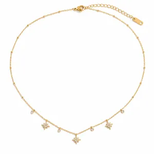 Detalle de elegante collar de acero dorado con colgantes de estrellas de ocho puntas y brillo