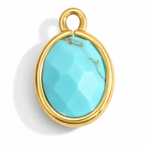 Detail view of a faceted oval turquoise stone set in a golden stainless steel pendant frame