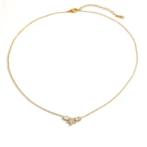 Primer plano de un collar de acero dorado con colgante de abeja y piedras de circón