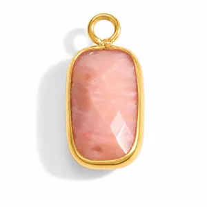 Detail view of a faceted pink natural stone pendant in a gold stainless steel frame