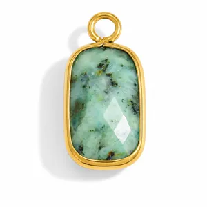 Detailed macro shot of rectangular green natural stone pendant with gold bezel