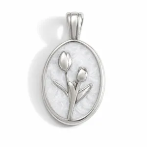 Gros plan détaillé d'un pendentif ovale en acier titane avec relief élégant de fleurs de tulipes