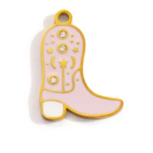 Détail macro d'un pendentif botte de cowboy en émail rose avec strass étincelants et étoiles
