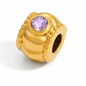 Dettaglio di un distanziatore in acciaio inossidabile placcato oro con pietra viola.
