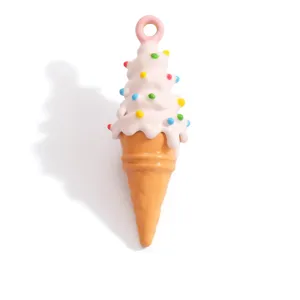 Close-up of pink swirl ice cream cone pendant with colorful sprinkles for DIY jewelry.