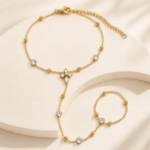 Detail van vergulde roestvrijstalen handketting met zirkoon bloemmotief