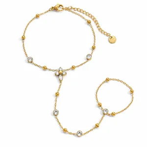 Gedetailleerde weergave van een vergulde handketting met zirkonia bloem en kralen.