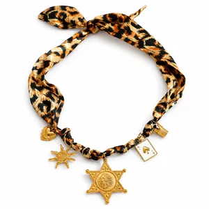 Detailed view of a leopard print scarf necklace with gold charms and pendants