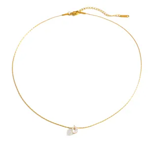 Vista detallada de un collar de acero de titanio chapado en oro con colgante de circonita