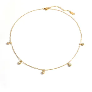 Detalle de collar de acero inoxidable dorado con colgantes de circón brillante