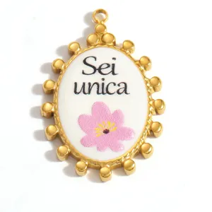 Detailed macro of oval stainless steel pendant with pink flower and Sei unica text
