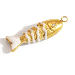 Nahaufnahme eines vergoldeten Fisch-Anhängers mit weißen Emaille-Details und Kristallauge.