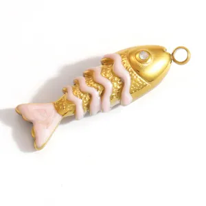 Detaillierte Nahaufnahme eines goldenen Fisch-Anhängers mit rosa Emaille und Strassstein