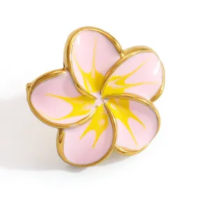 Close-up of pink and yellow enamel plumeria flower shoe charm with gold metal edge.