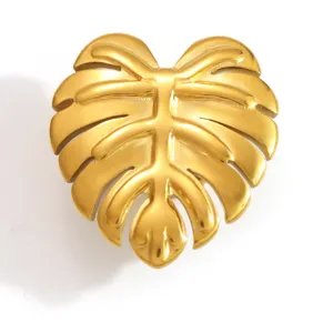 Detailed macro view of a polished golden Monstera leaf charm for clogs made of stainless steel