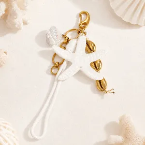Détail d'un porte-clés étoile de mer avec coquillages dorés et boucle en corde