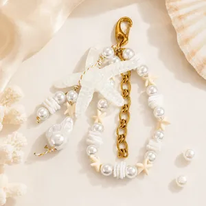 Détail macro du bijou de sac thème océan avec étoile de mer blanche et perles nacrées