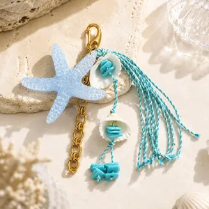 Vue détaillée de l'accessoire de sac étoile de mer avec pompons et chaîne dorée