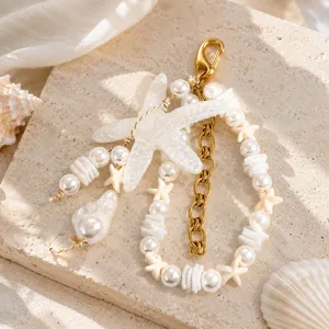 Détail d'un bijou de sac thème océan avec étoile de mer, perles et chaîne d'or