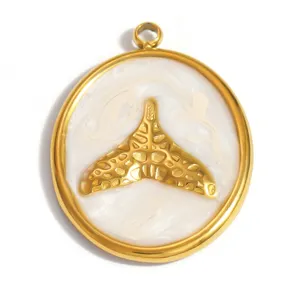 Close-up macro view of a gold whale tail pendant with white marble enamel finish