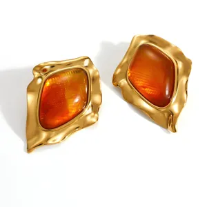 Macro view of vintage gold-plated earrings with amber resin and lattice texture