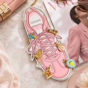 Dijes creativos de acero inoxidable para zapatos en dorado sobre una tarjeta rosa