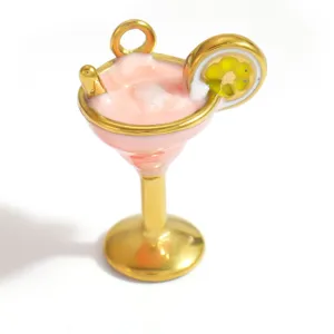 Vista detallada de un colgante de joyería con forma de cóctel rosa chapado en oro.