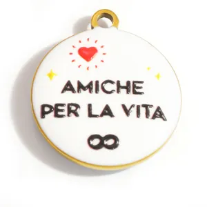 Dettaglio macro di un ciondolo in smalto bianco con cuore e scritta Amiche per la vita.